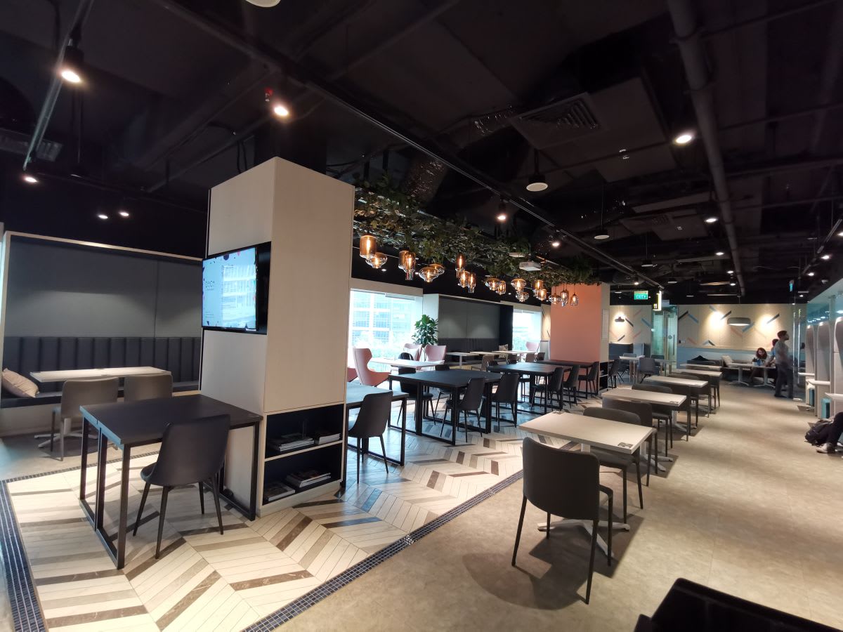 Modern coworking space with diverse seating, natural light, and stylish decor on Clemenceau Ave.