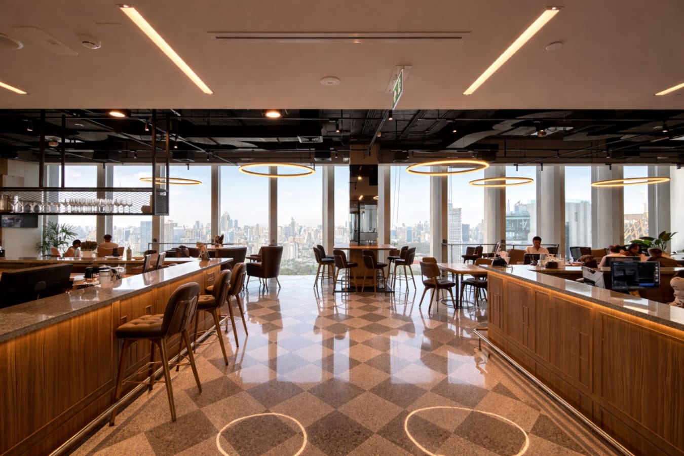 Stylish coworking space with city views, ample seating, and modern lighting in Bang Rak, Bangkok.