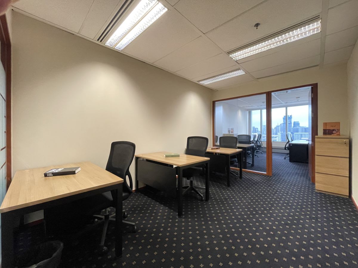 Modern coworking space with ergonomic chairs, ample natural light, and city views.