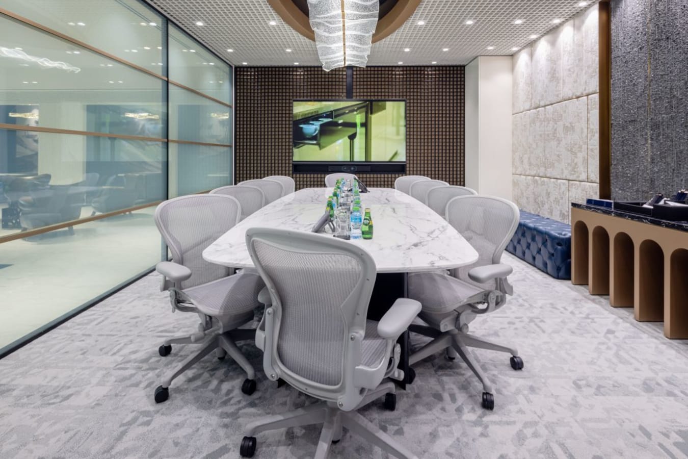 Modern conference room with sleek marble table, ergonomic chairs, and vibrant lighting.