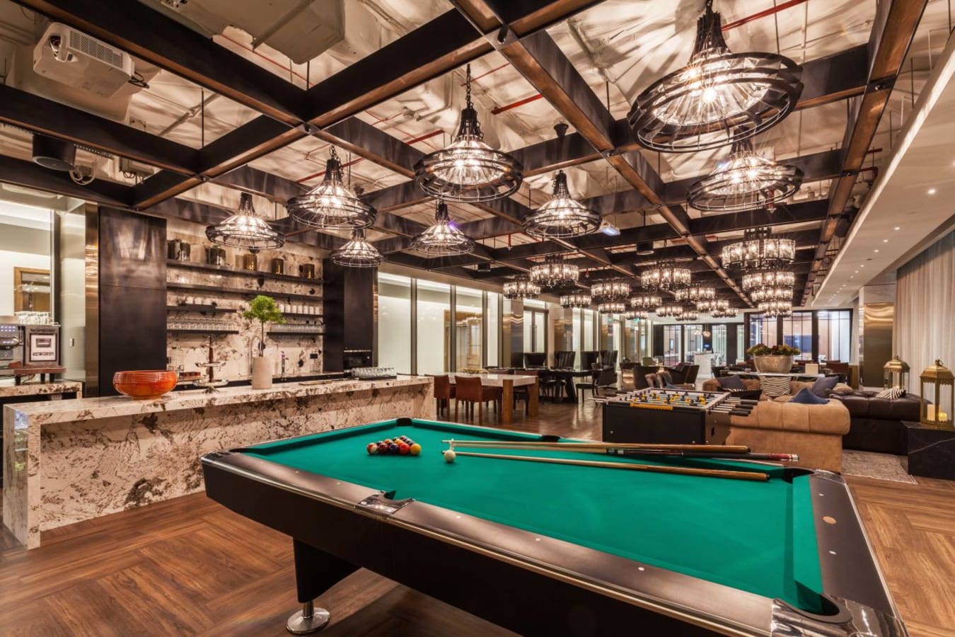 Vibrant coworking space with chic lighting, a pool table, and cozy seating on Sheikh Zayed Road.