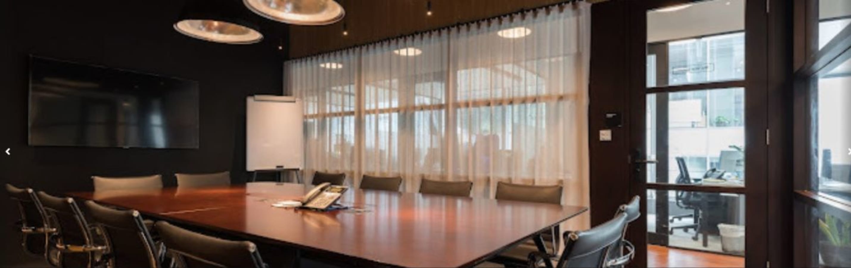 Elegant conference room with seating for ten, equipped with modern AV and stylish lighting.