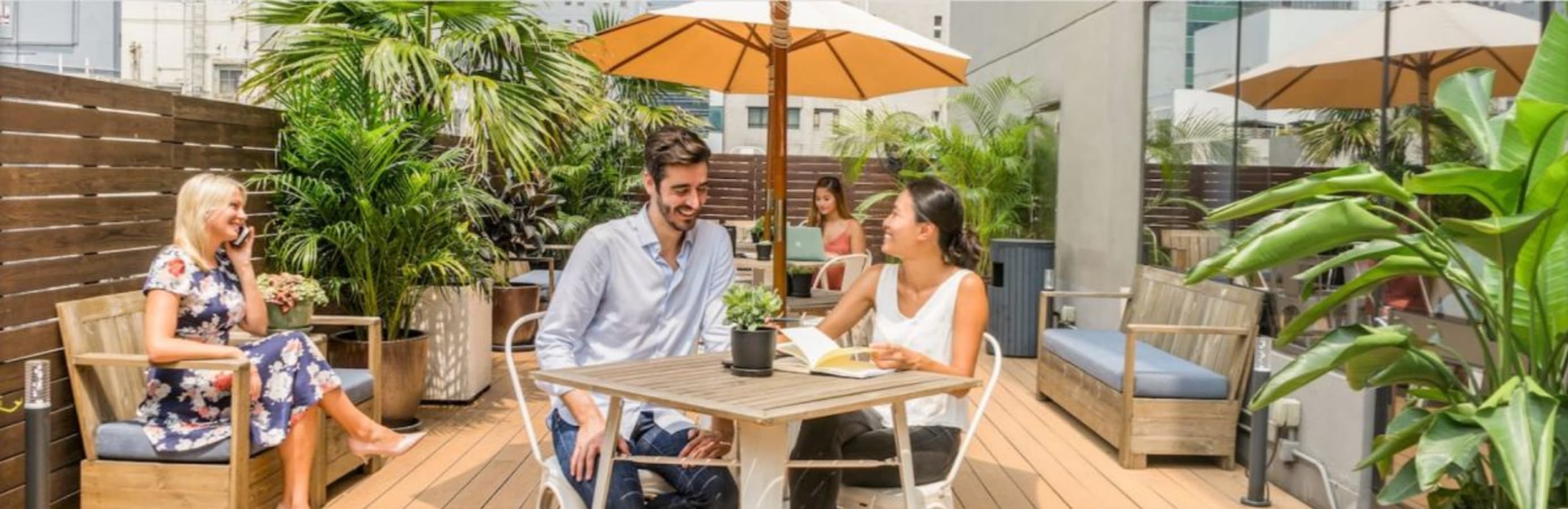 Vibrant outdoor coworking area with lush greenery and relaxed seating on Luard Road, Hong Kong Island.