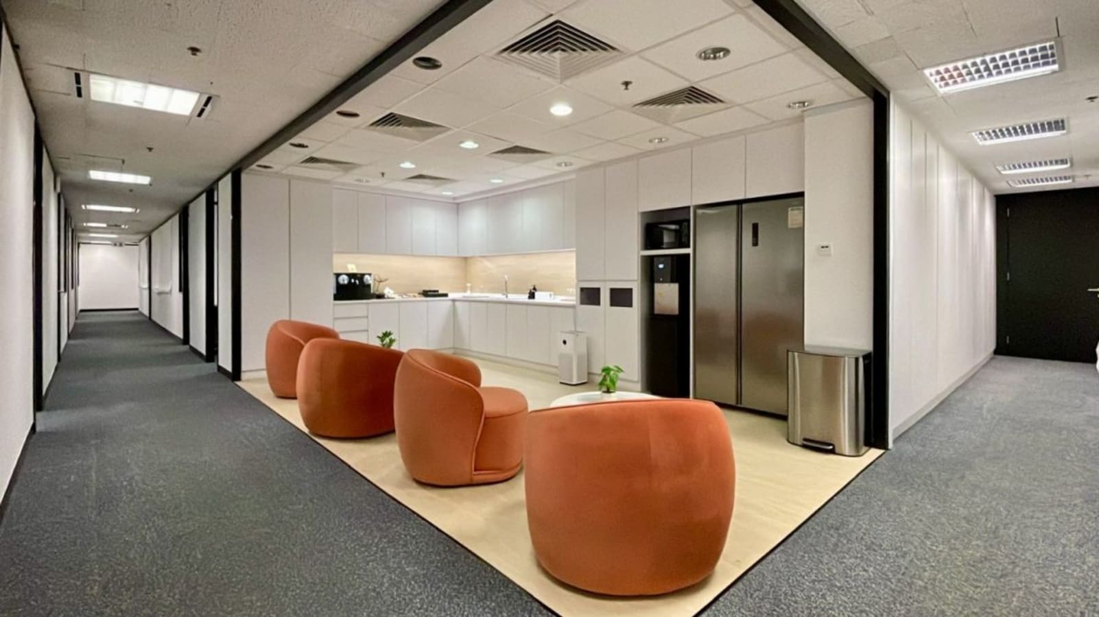 Chic coworking space with modern seating and fully-equipped kitchenette. Ideal for collaboration.