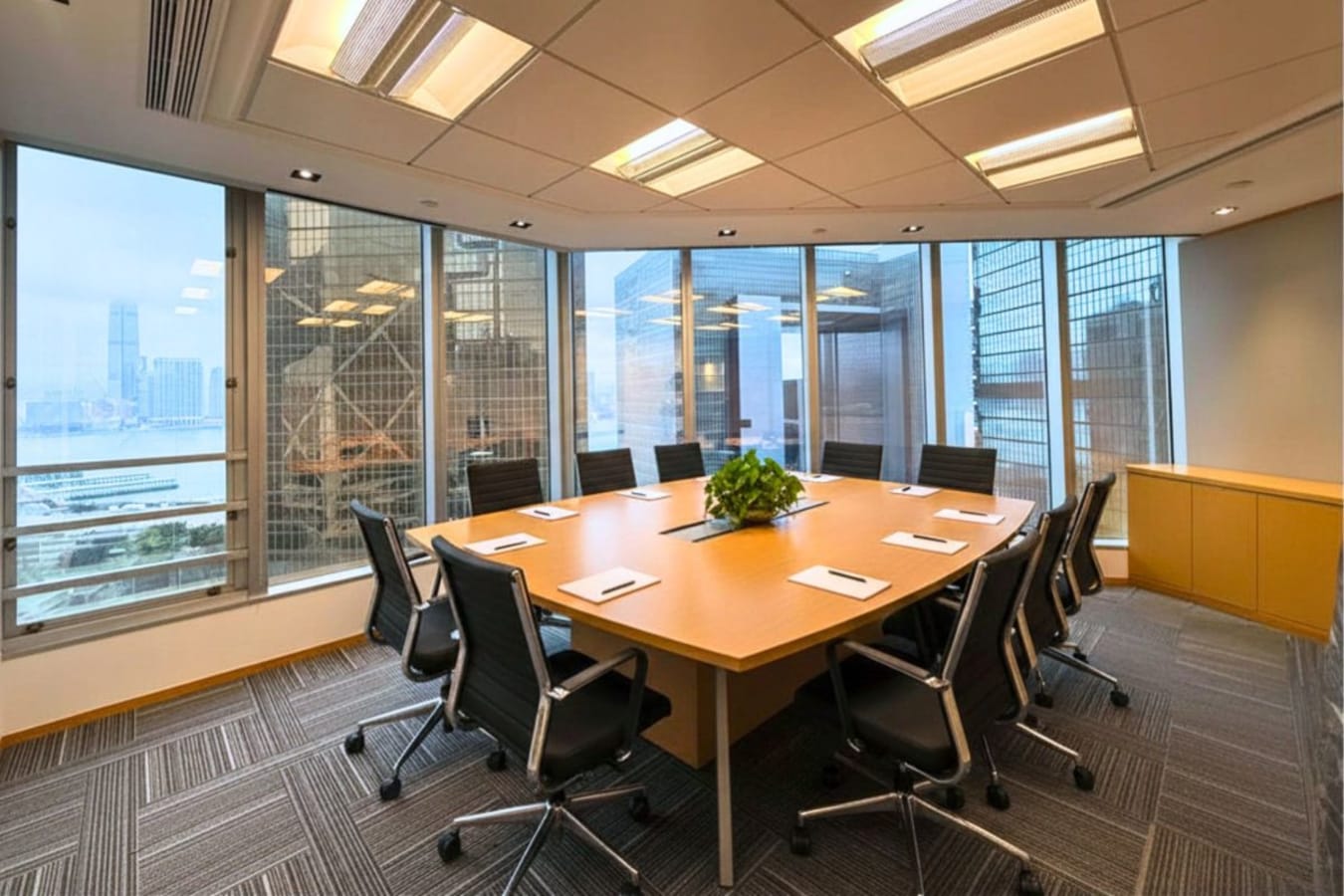 Modern conference room with city views, ergonomic seating, and ample natural light. Ideal for meetings.