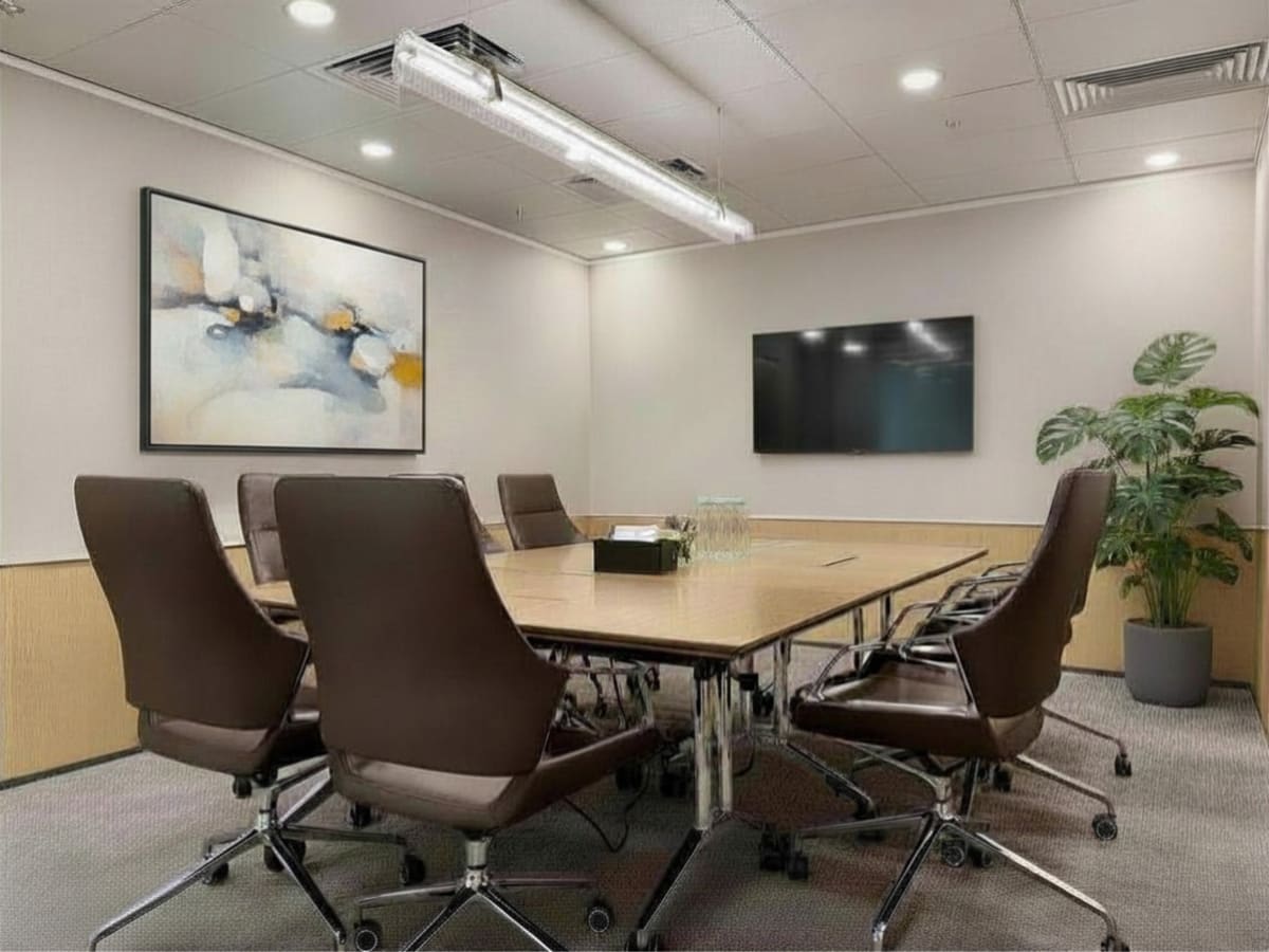 Sleek conference room with modern chairs, wall art, and a large screen. Perfect for meetings.