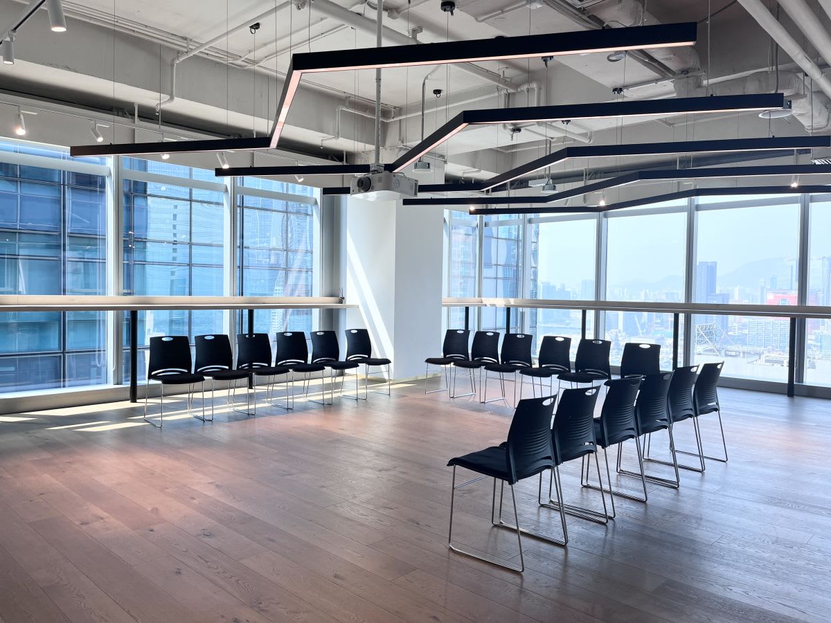 Bright, open coworking space with city views and modern seating arrangement. Perfect for collaboration.