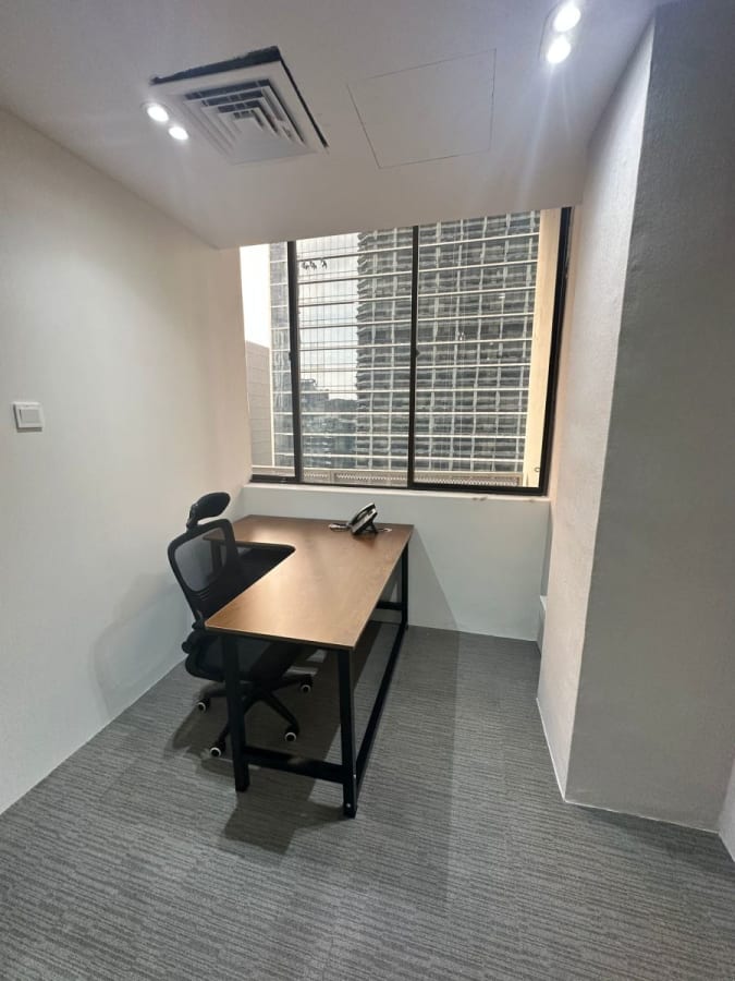 Compact office with natural light and city view, perfect for focused work.