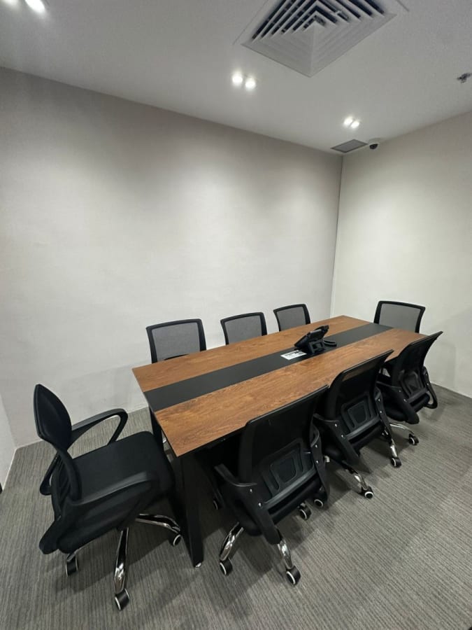 Modern meeting room with sleek table and ergonomic chairs, ideal for collaborative sessions.