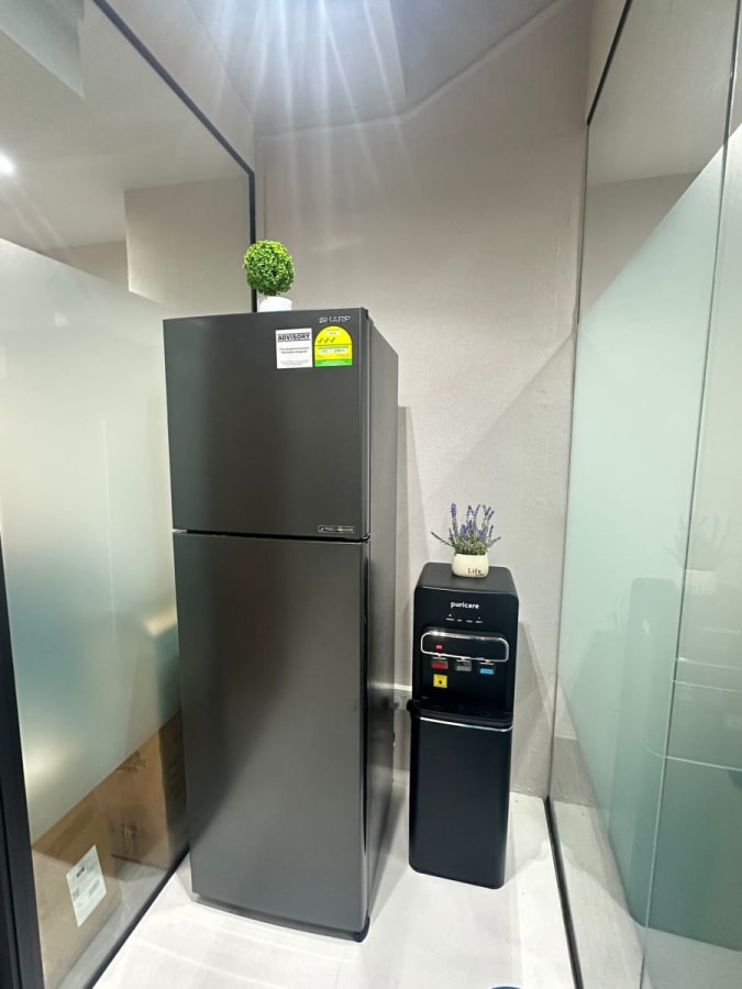 Convenient kitchenette with sleek fridge and water dispenser for your refreshment needs.