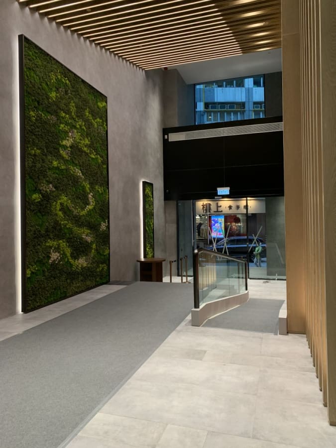 Modern coworking space with green walls and sleek, open design in Sheung Wan. Ideal for productivity.