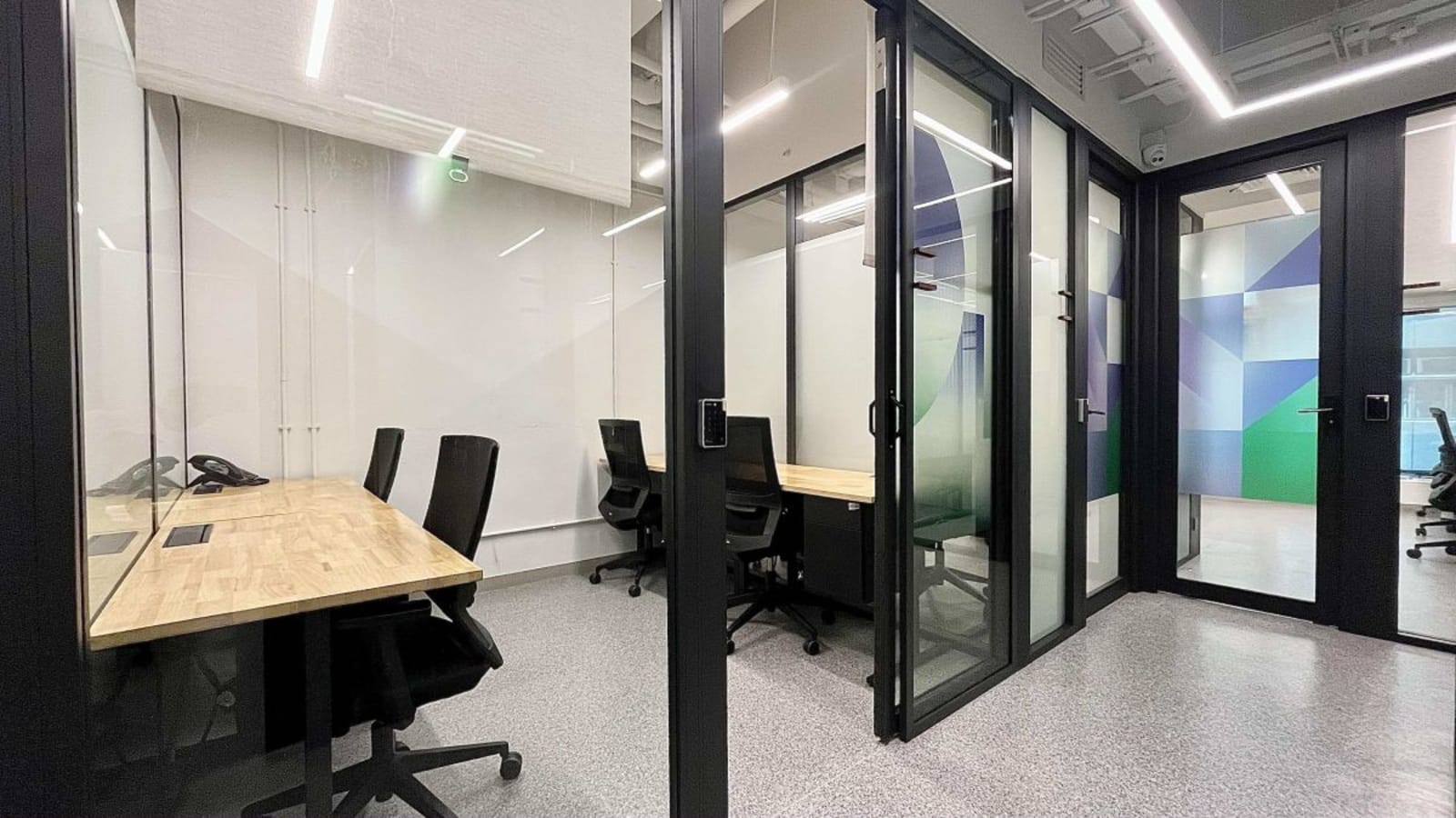 Modern coworking space with private offices, sleek furnishings, and ample natural light in Sheung Wan.