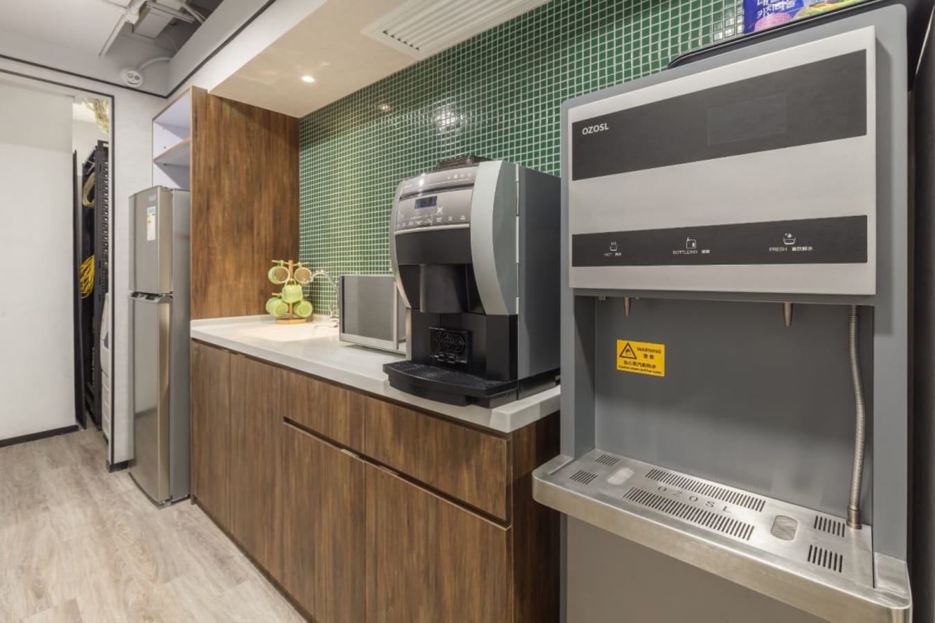 Modern kitchenette with coffee machine and fridge; perfect for coworking breaks in Kowloon.