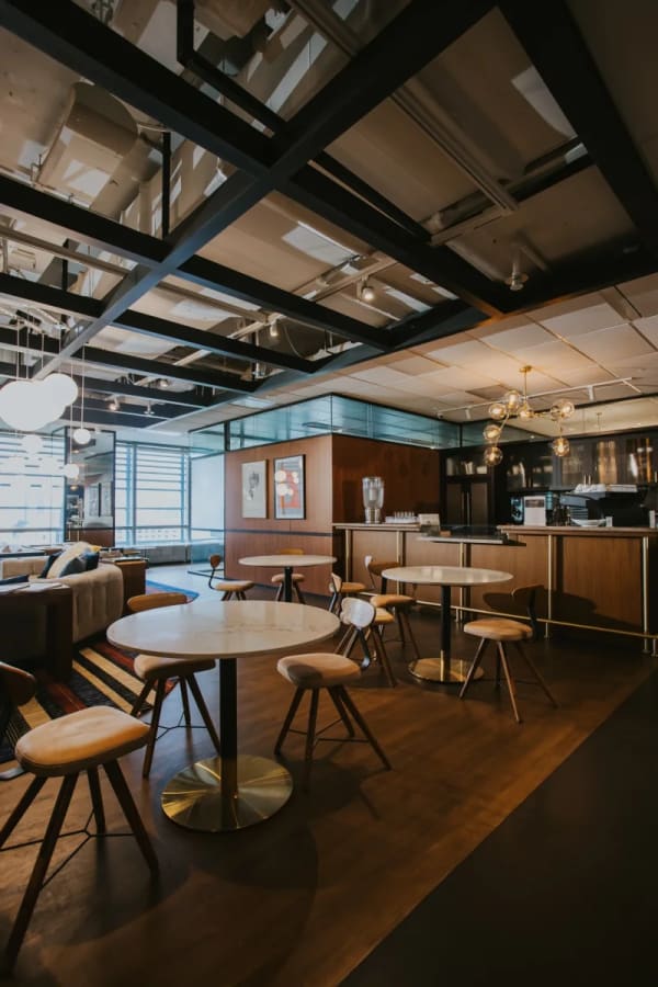 Modern coworking space with cozy seating, natural lighting, and a stylish open kitchen area. Perfect for collaboration.