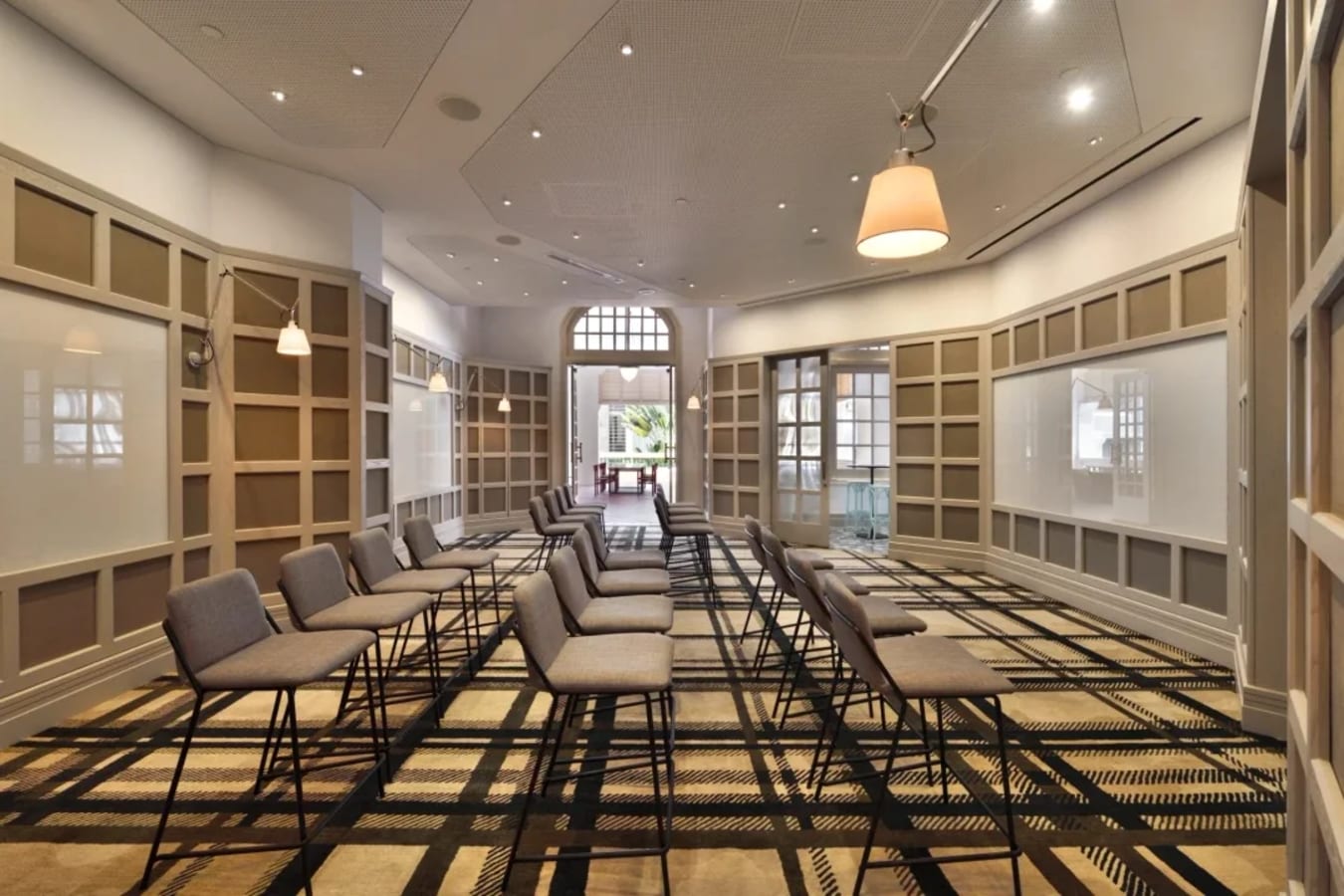 Spacious, elegant meeting room with ample seating and modern lighting, perfect for events and workshops.