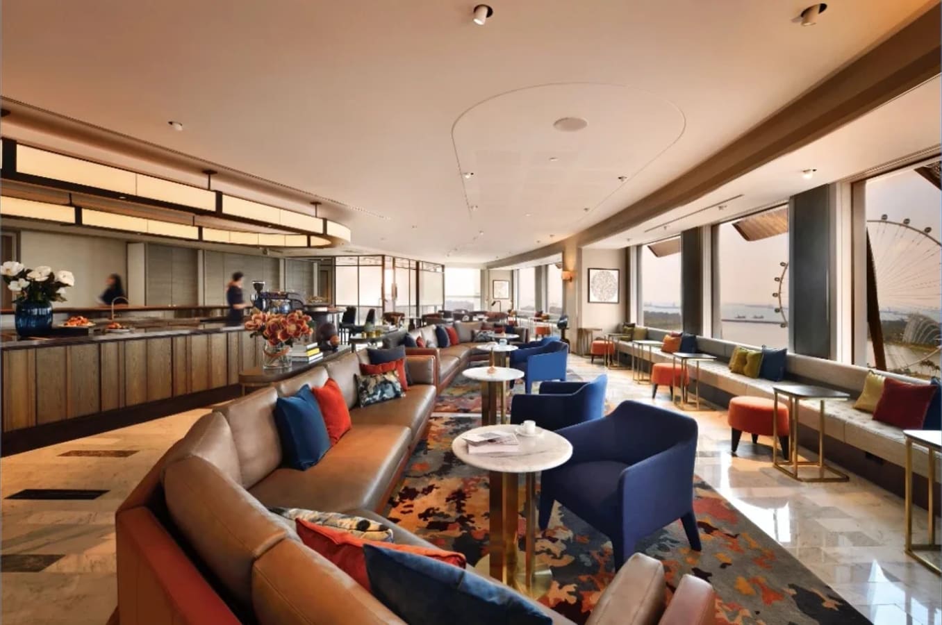 Elegant coworking space with plush seating, vibrant decor, and panoramic city views.