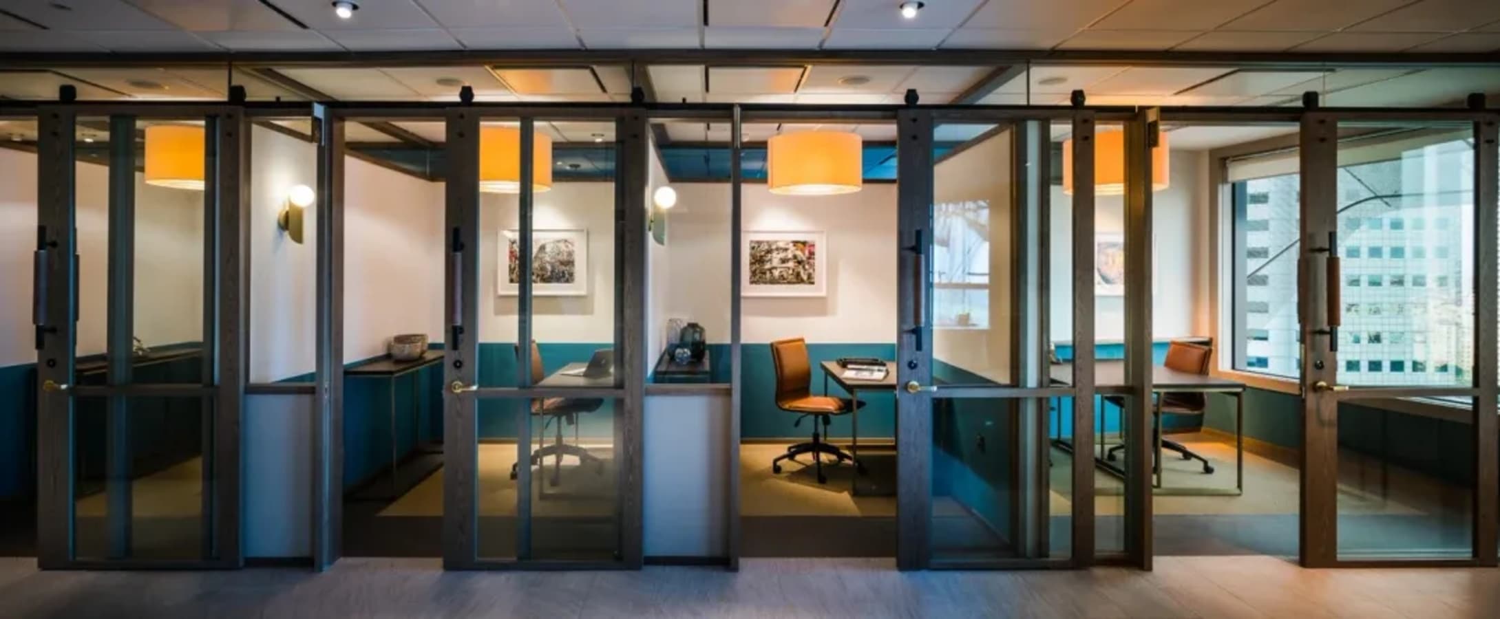 Stylish glass-partitioned offices with modern lighting, perfect for collaboration and privacy.