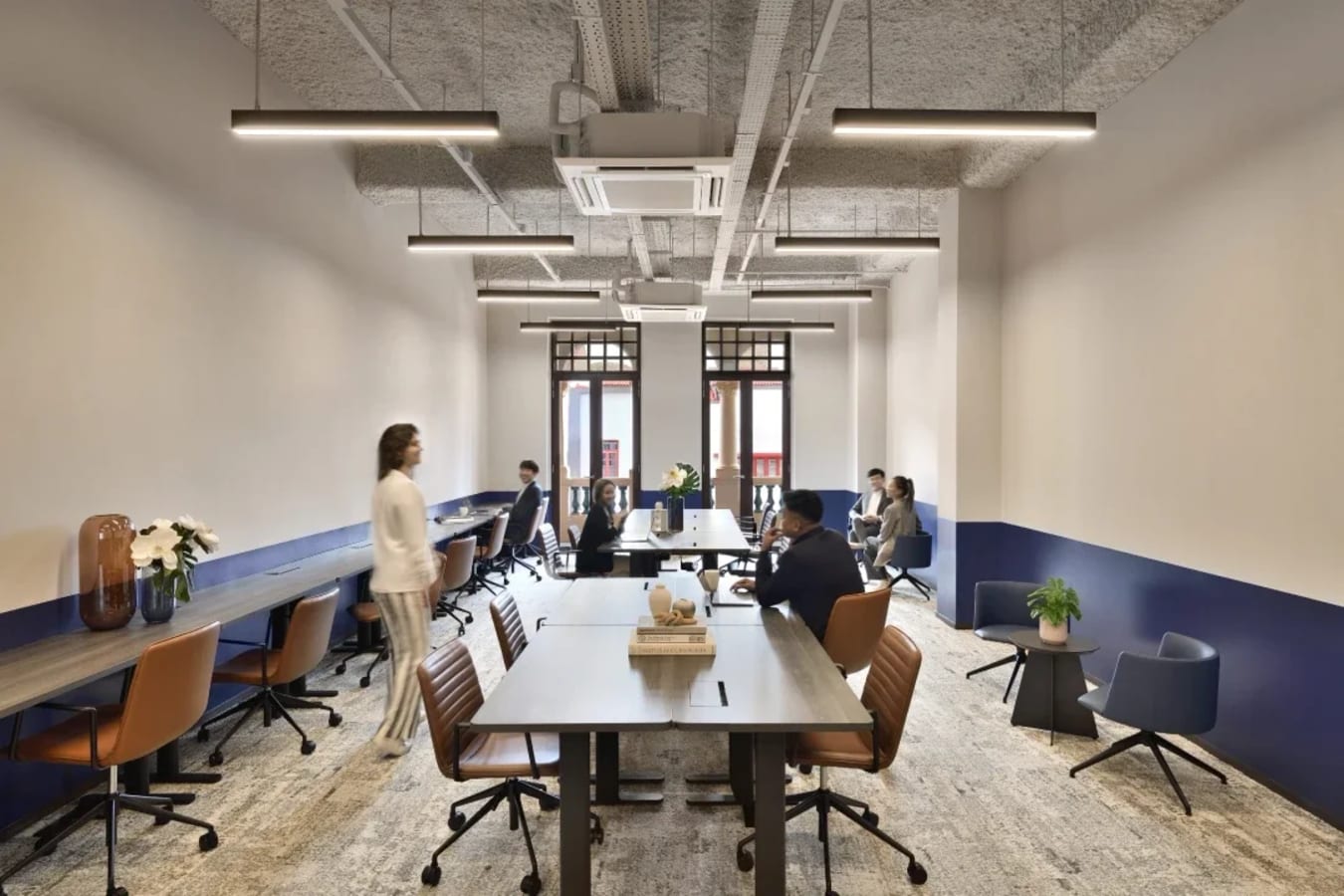 Modern coworking space with stylish seating, ample natural light, and collaborative layout.