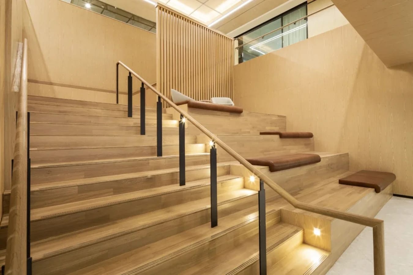 Elegant tiered seating area with modern wood accents, perfect for relaxed meetings or breakout sessions.