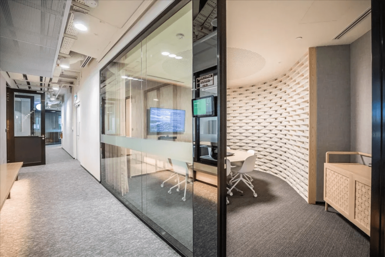 Modern coworking space with glass offices, sleek furniture, and ample natural light in Singapore.