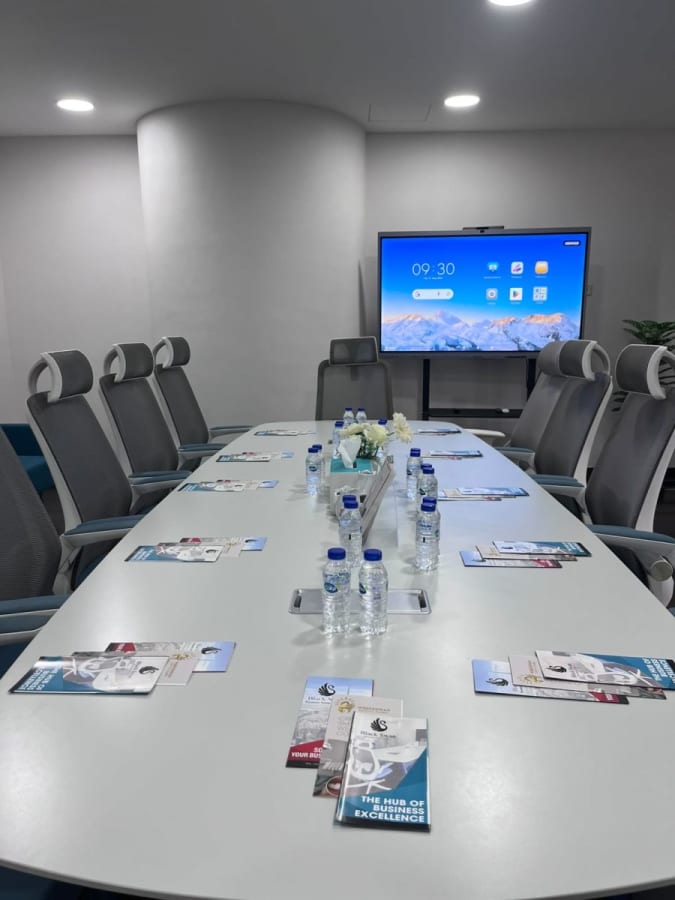 Modern meeting room with sleek chairs, large screen, and a spacious table in Dubai's Marasi Drive.