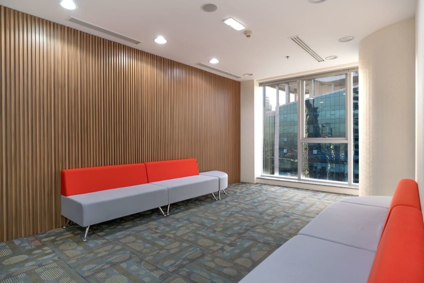 Modern coworking lounge with vibrant seating and city views on Marasi Drive, Dubai.