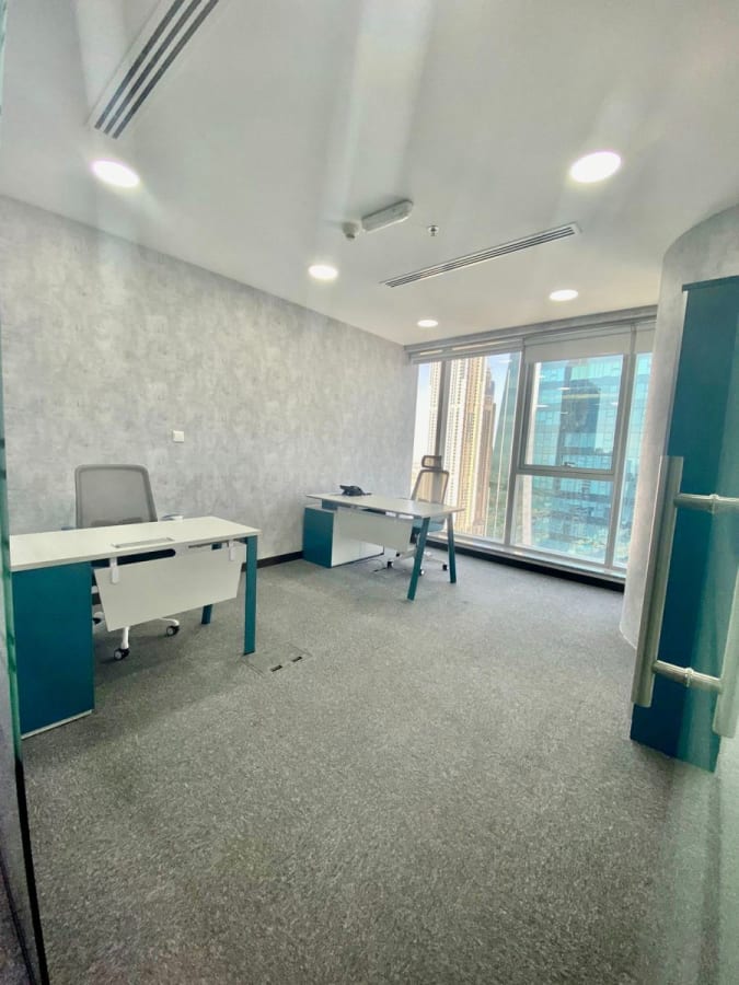 Bright coworking space with large windows, modern desks, and city views in Marasi Drive.