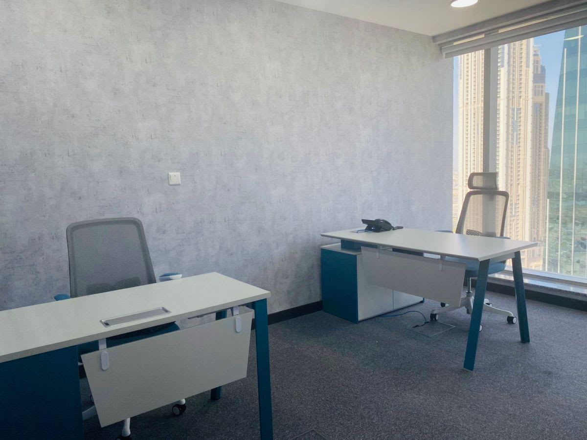 Bright coworking space with modern desks and stunning Dubai skyline views.