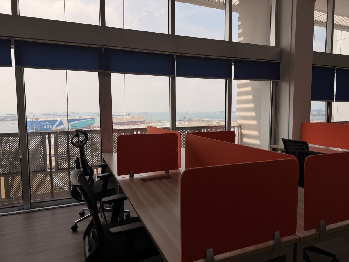 Modern coworking space with bright desks, ergonomic chairs, and sea views. Ideal for productivity.