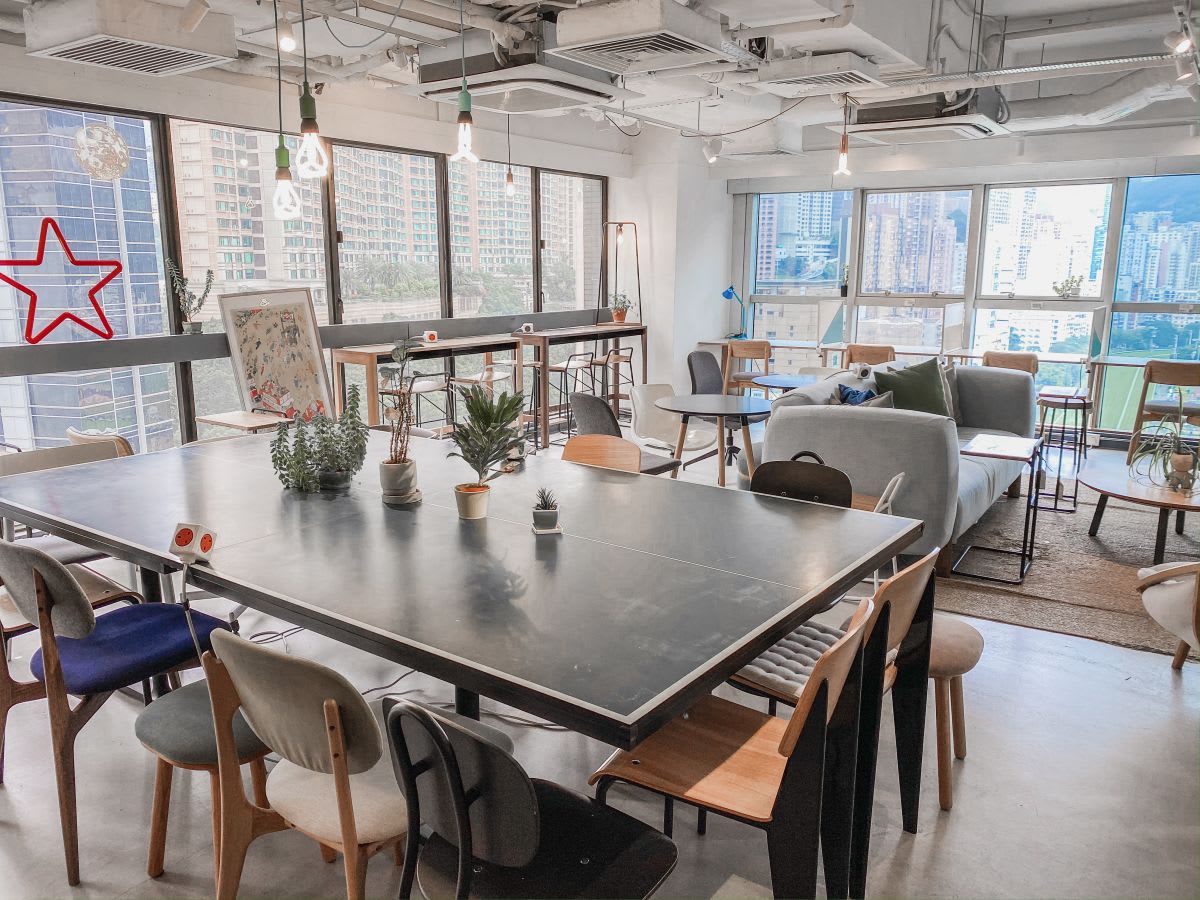 Bright coworking space with modern decor, ample natural light, and vibrant city views.