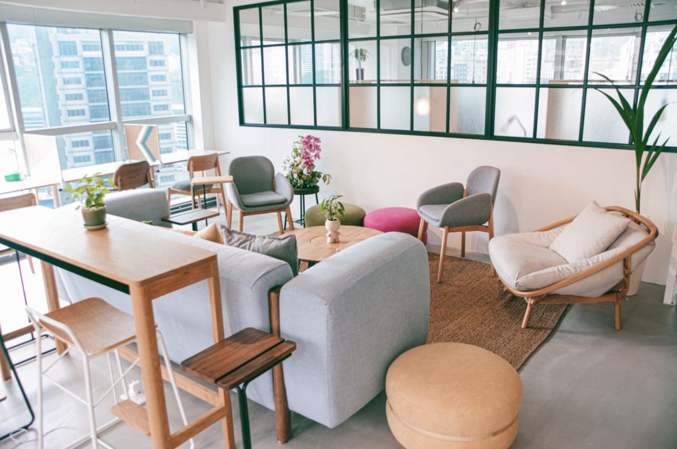 Modern coworking space with cozy seating, natural light, and greenery in Hong Kong Island.