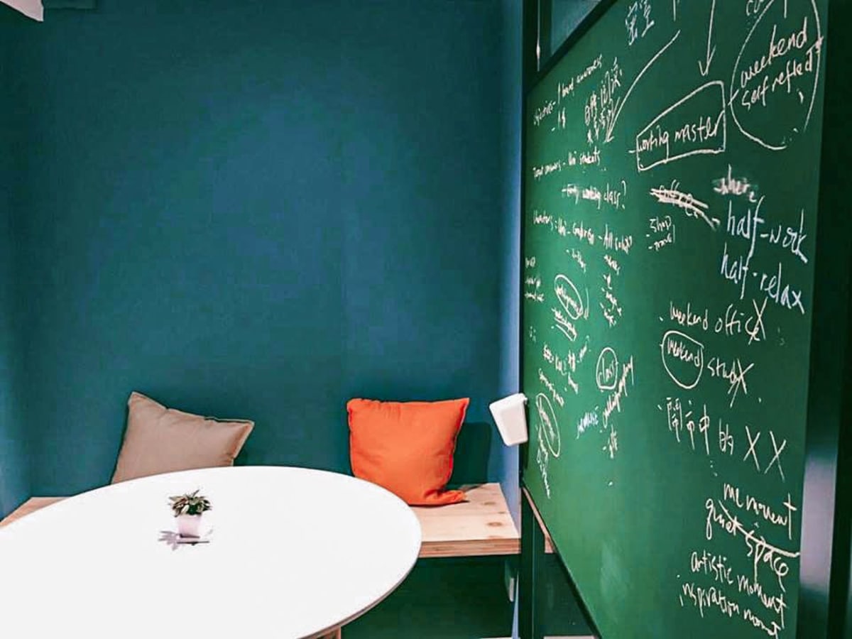 Inspiring coworking nook with chalkboard wall, cozy bench seating, and stylish accents.