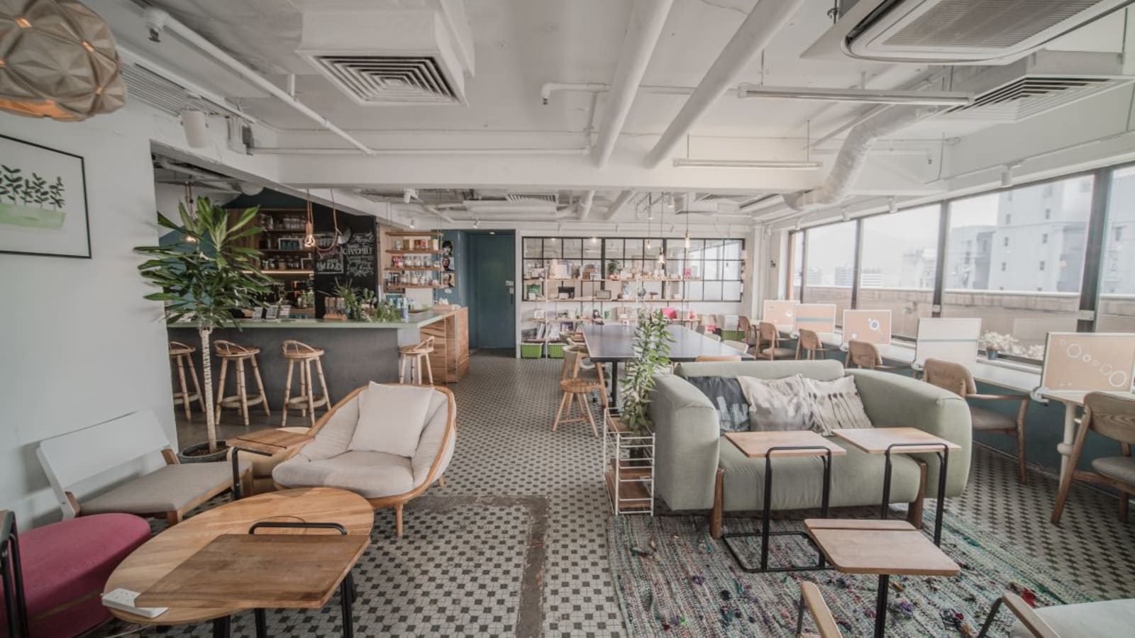 Stylish coworking space with open seating, a cozy lounge area, and a vibrant bar on Shantung Street.