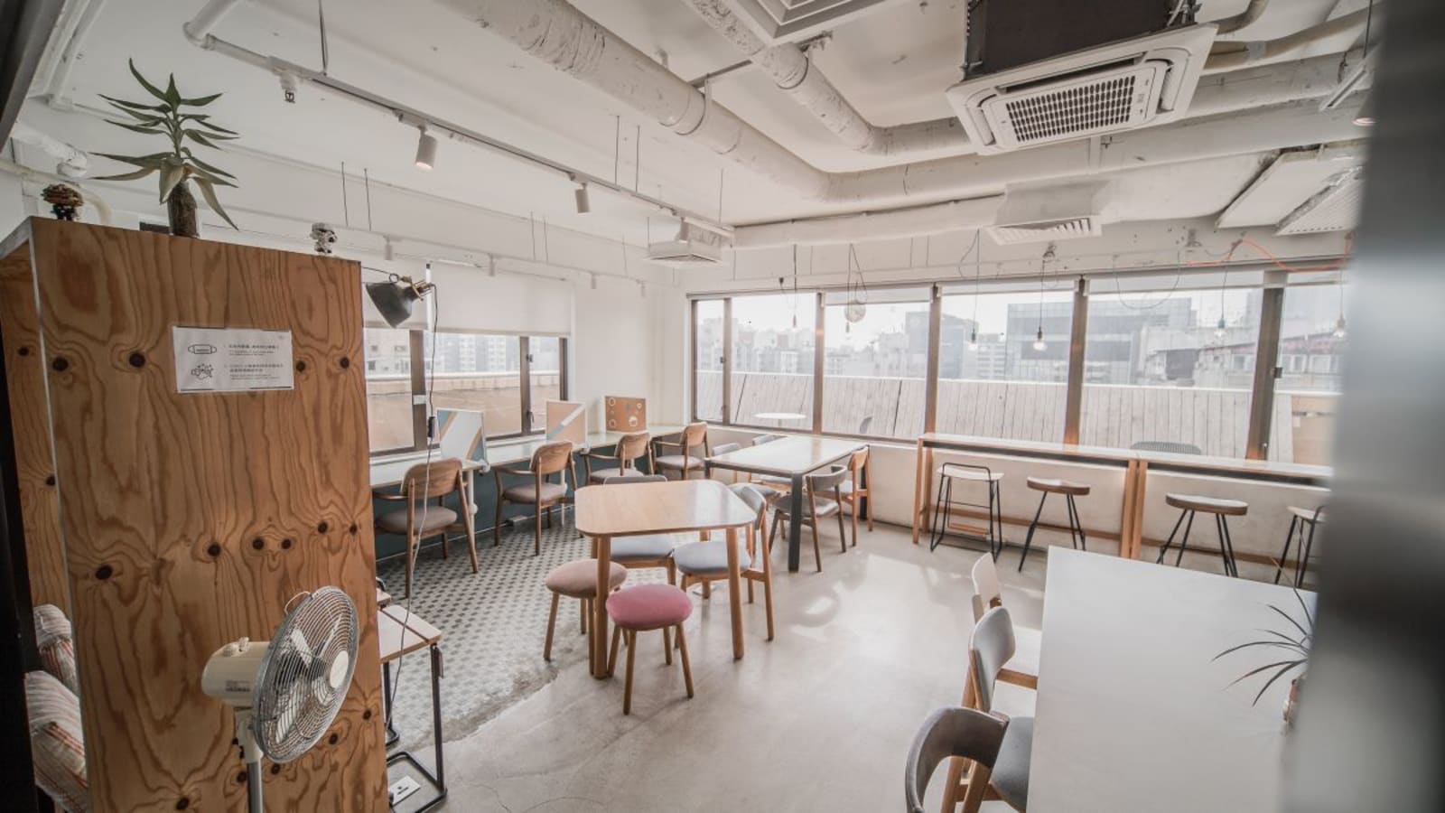 Bright coworking space with natural light, modern seating, and city views on Shantung Street.