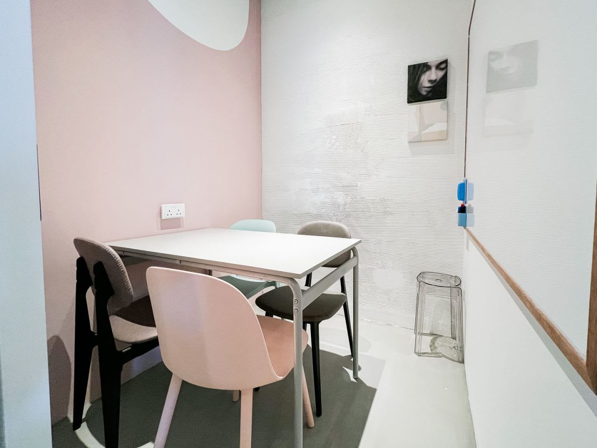 Cozy meeting nook with pastel chairs and a clean, minimalist design. Ideal for small team huddles.