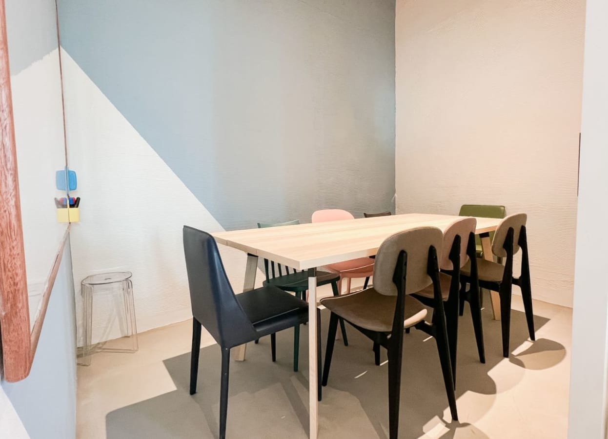 Colorful meeting room with modern chairs and a sleek table, perfect for collaboration.