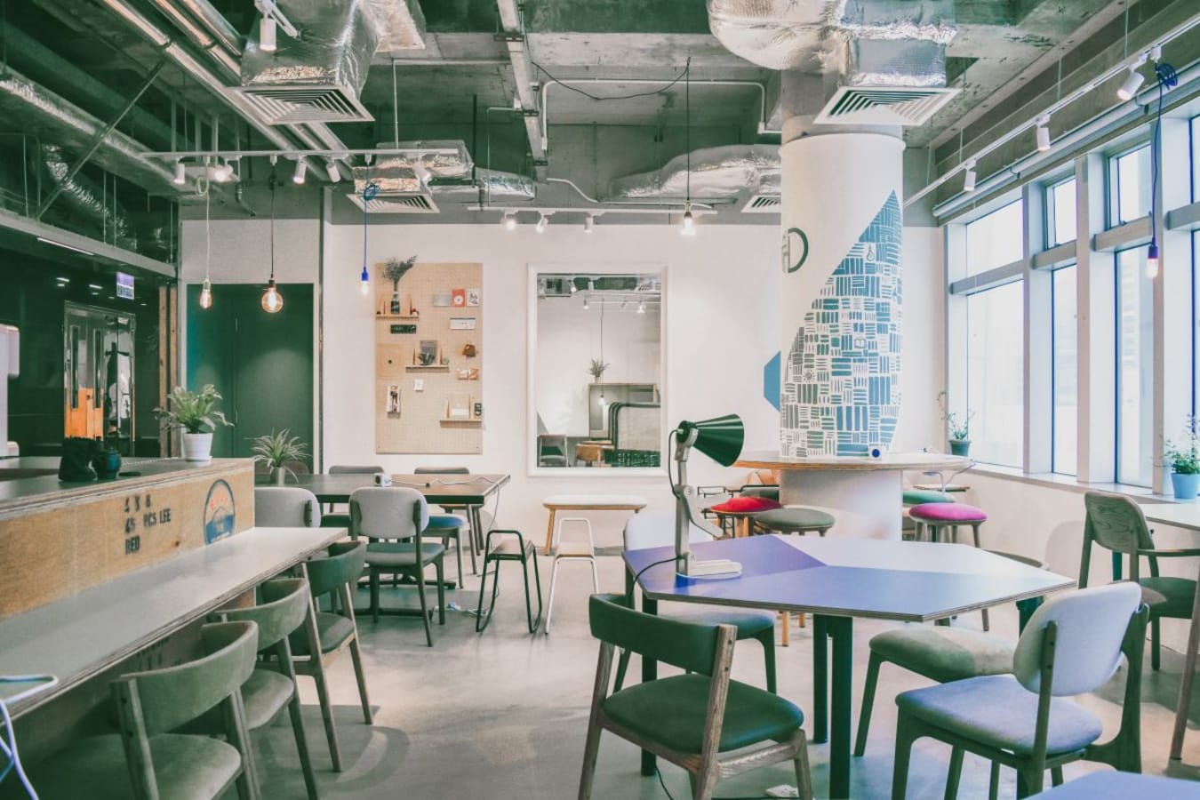 Stylish coworking space with modern décor, natural light, and versatile seating options.