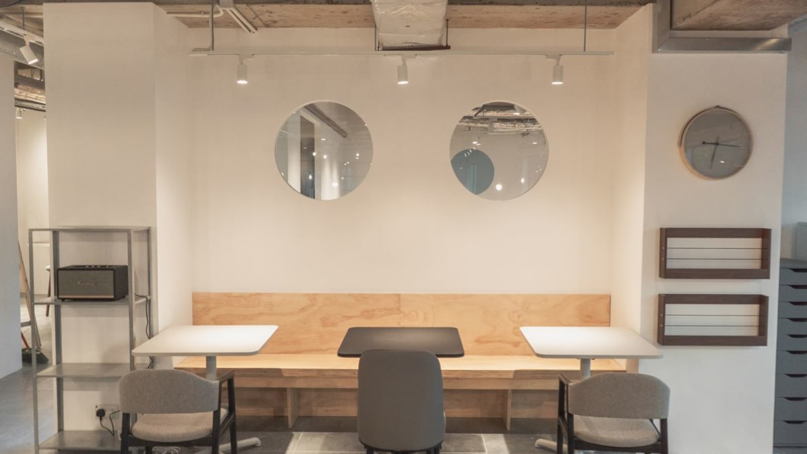Modern coworking area with sleek tables, cozy seating, and stylish wall accents.