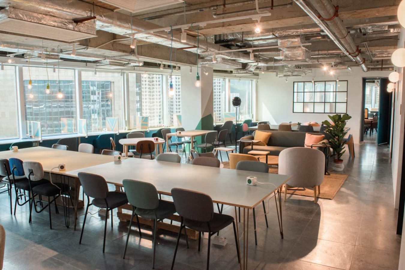 Bright coworking space with modern decor, ample seating, and natural light in Sha Tin.