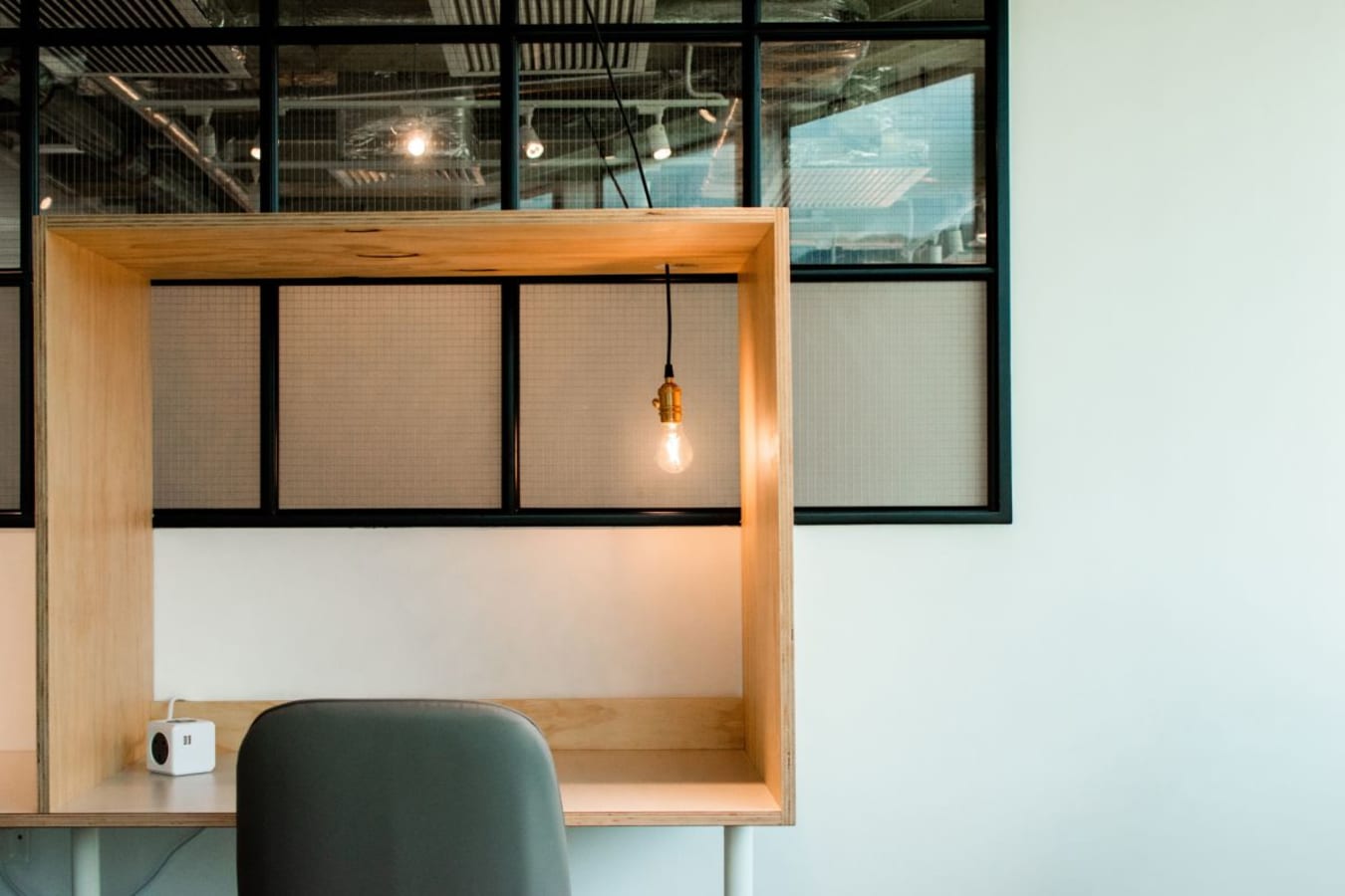 Modern coworking desk with warm lighting and a minimalist design, perfect for focused work.