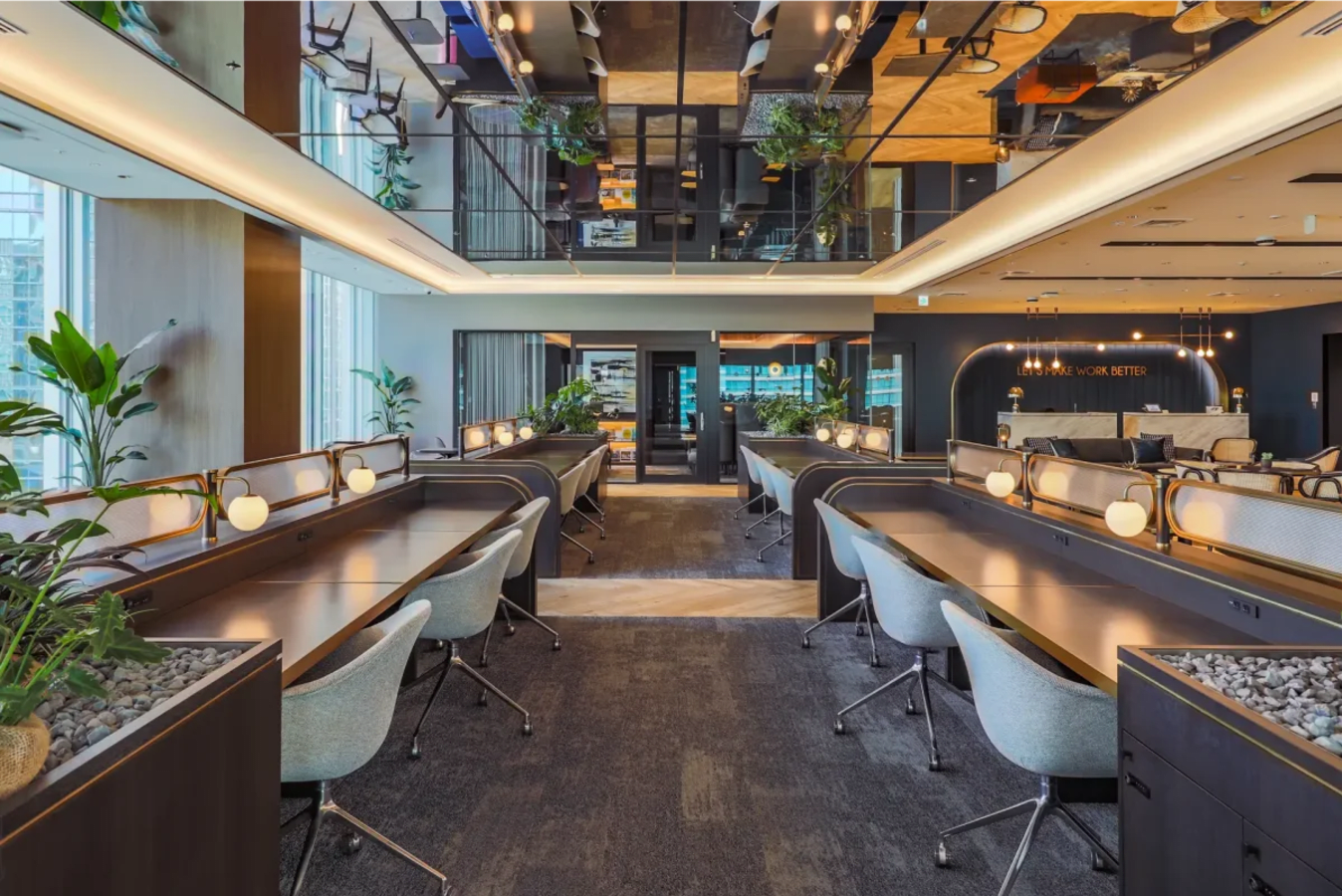 Modern coworking space in Marunouchi with sleek desks, ample lighting, and lush greenery.