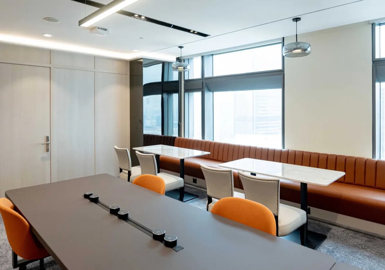 Modern coworking area with ample natural light, stylish seating, and collaborative tables.