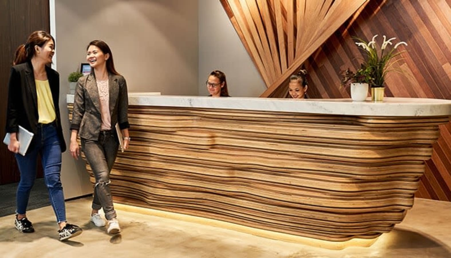 Welcoming reception area with modern wood accents and friendly staff at Gateway Drive coworking space.