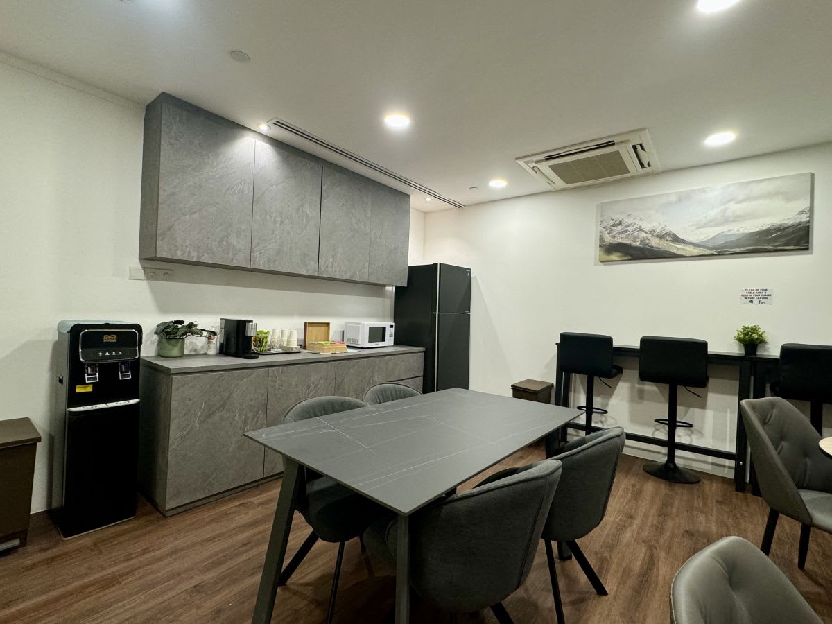 Modern coworking pantry with sleek countertops, comfortable seating, and ample lighting on Anson Road.