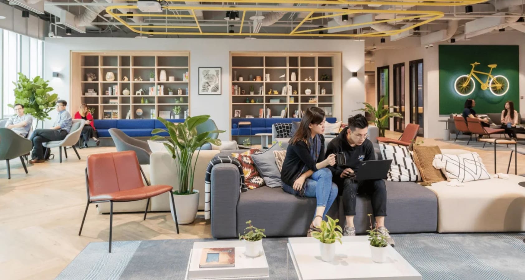 Modern coworking space with open lounge, stylish decor, and ample natural light. Ideal for collaboration.