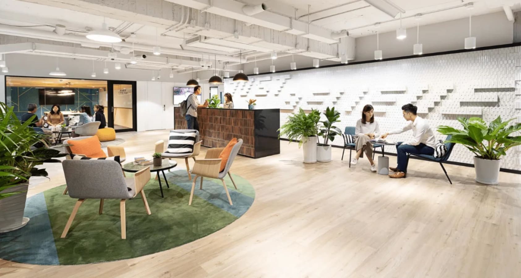 Modern coworking space in Taipei featuring stylish seating, vibrant lighting, and natural accents.