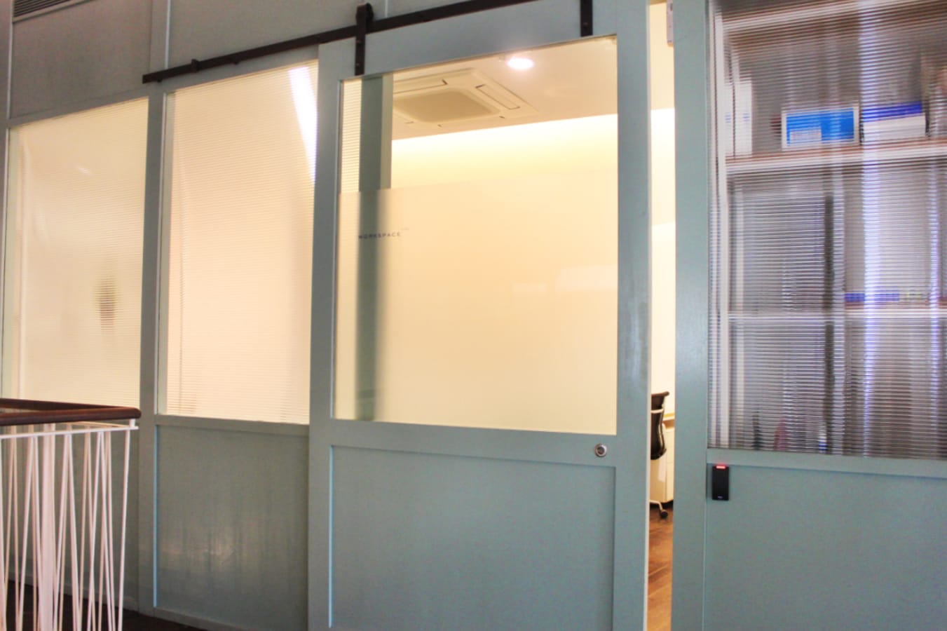 Modern coworking space with frosted glass doors and ample natural light on Keong Saik Road.
