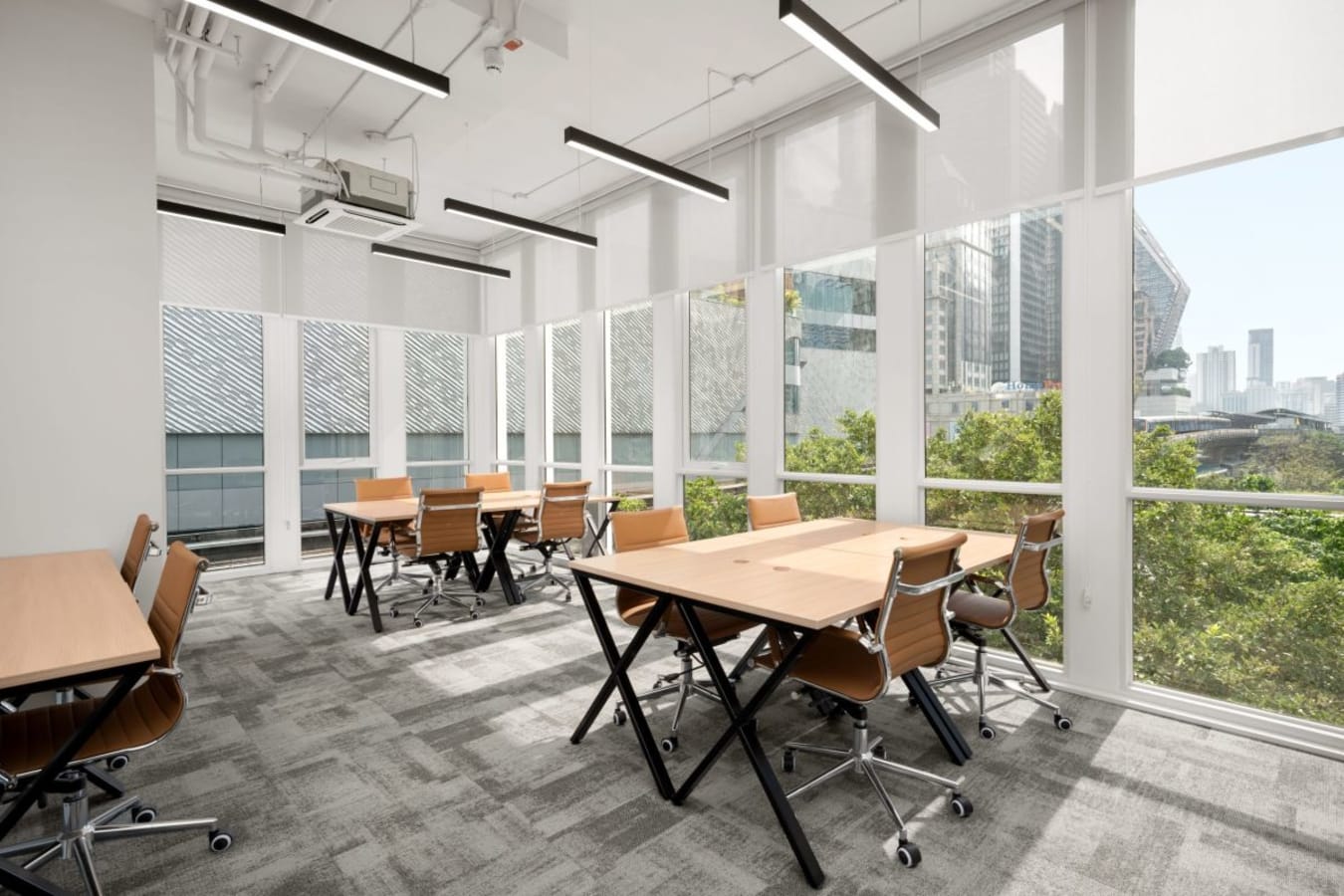 Bright coworking space with modern furniture and city views, perfect for dynamic collaboration.