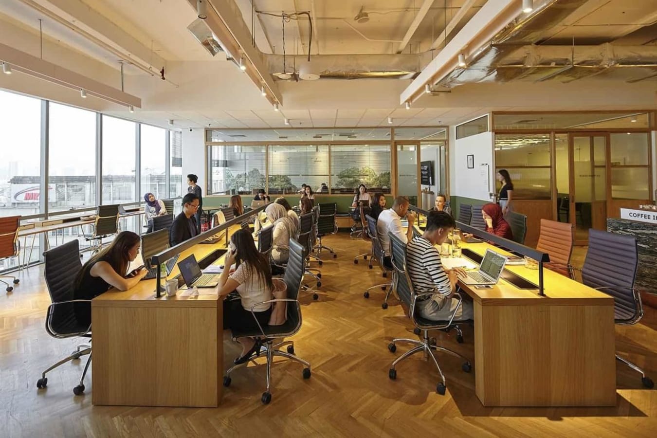Vibrant coworking space with modern seating, hardwood floors, and ample natural light. Ideal for productivity.