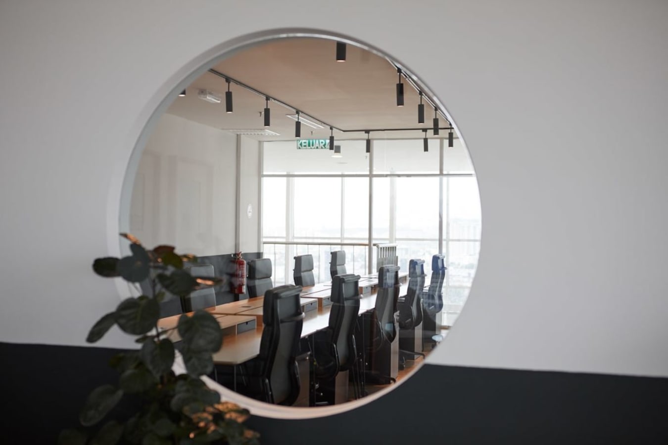 Modern coworking space with sleek boardroom, ample seating, and natural light.